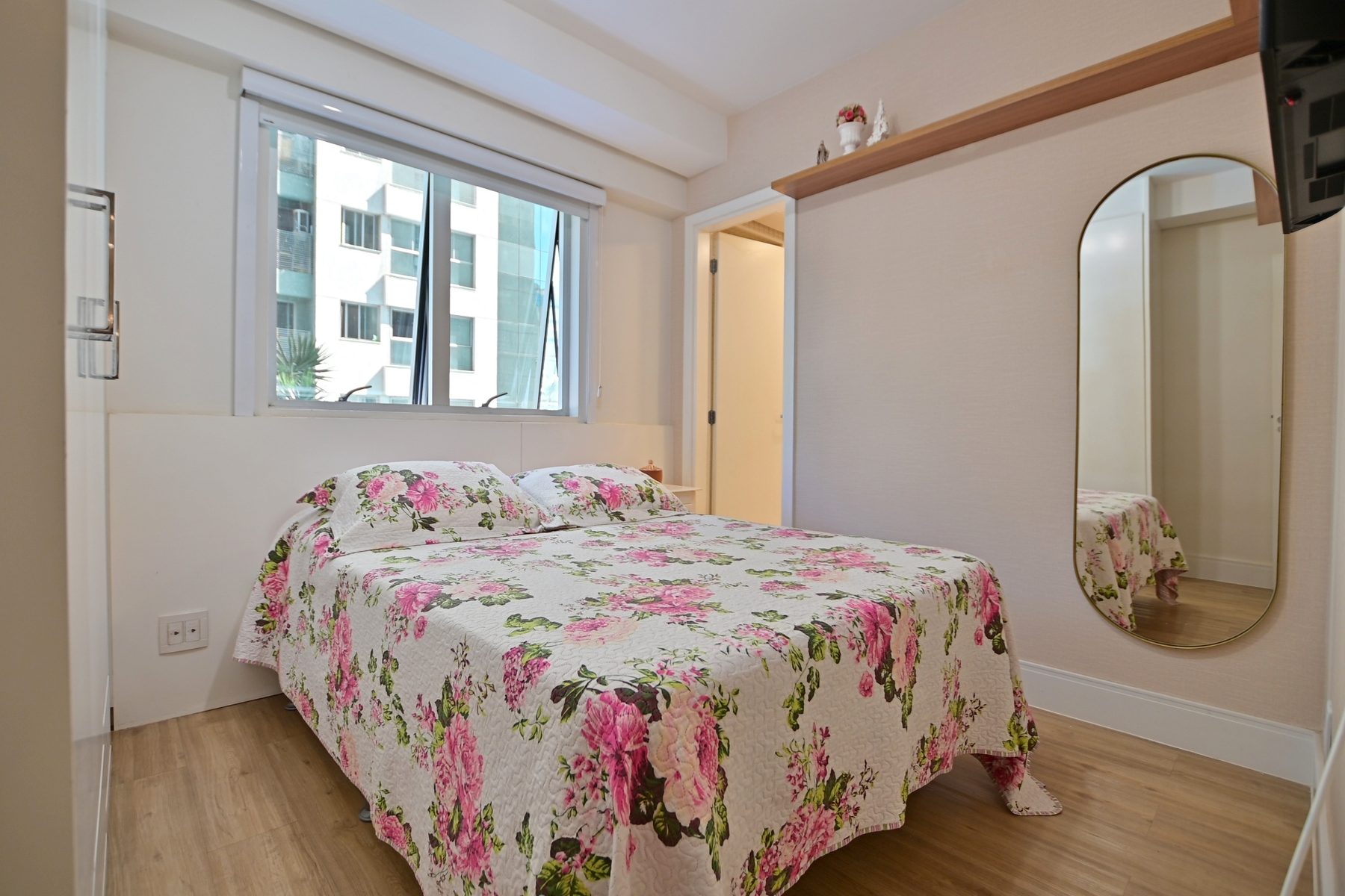 Quarto com cama de casal, armário embutido e janela ampla