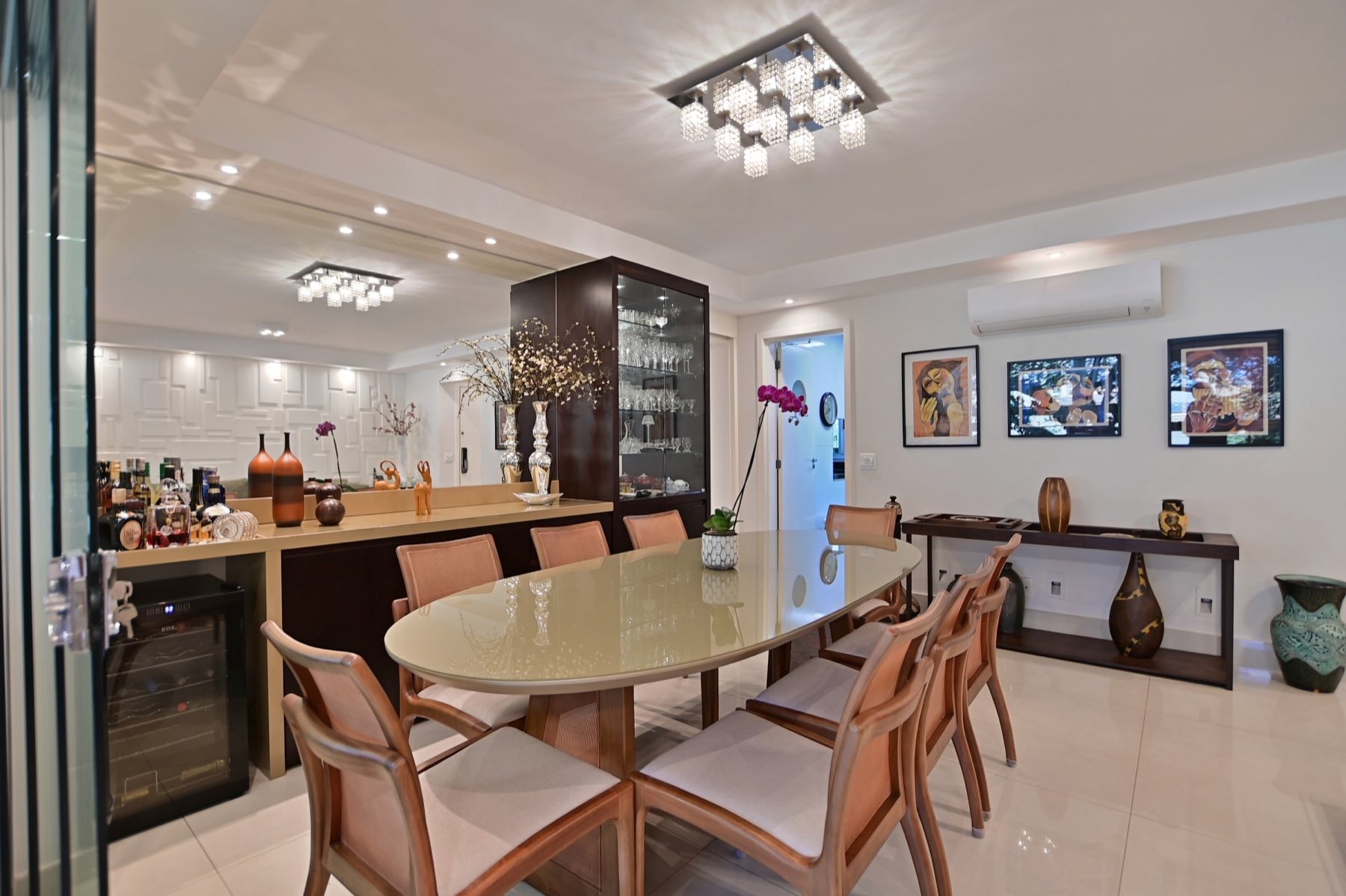 Sala de jantar com mesa oval, adega climatizada e bar